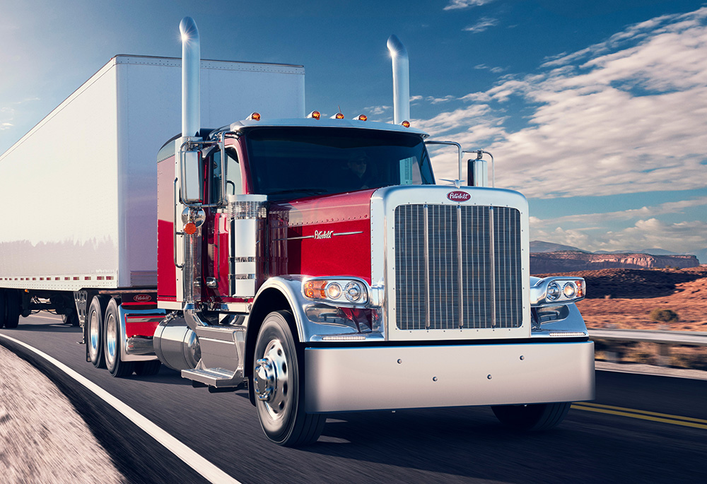 Red Peterbilt 589 driving through the desert